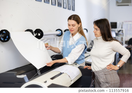 Printing office manager and employee loading printer with paper Printing office manager and employee loading printer with paper 113557916