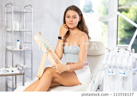 Young joyful woman examining her face after cosmetic procedure 113558137