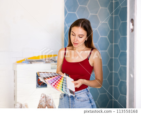 Owner of cottage selects color of ceramic tiles according to color patterns 113558168