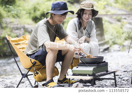 A young man and woman making yakisoba on a gas stove on a riverbed Outdoor image A young man and woman making yakisoba on a gas stove on a riverbed Outdoor image 113558572