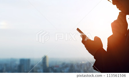 一個男人一邊看智慧型手機一邊思考的剪影 113561506