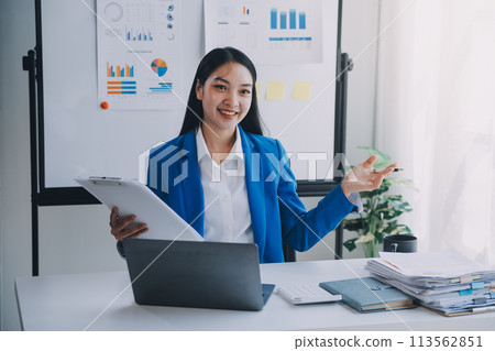 Cheerful business lady working on laptop in office, Asian happy beautiful businesswoman in formal suit work in workplace. Attractive female employee office worker smile. 113562851