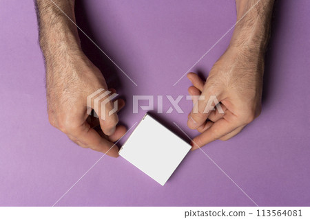 Male hand holding a pill box in front of purple background mock-up series  113564081