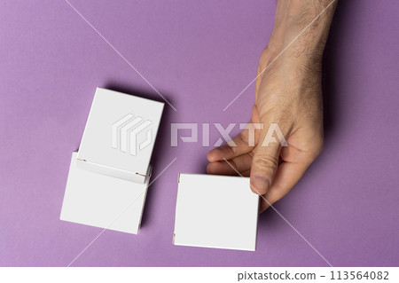 Male hand holding a pills box in front of purple background mock-up series  113564082