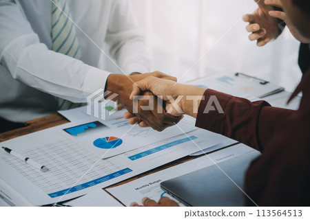 Real estate agent and customers shaking hands together celebrating finished contract after about home insurance and investment loan, handshake and successful deal. 113564513