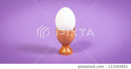 Wooden eggcup isolated on purple background Wooden eggcup isolated on purple background 113564981