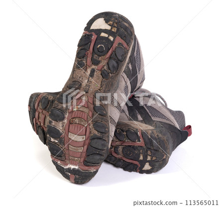 Worn-out muddy lace-up hiking boots, no live in them anymore 113565011