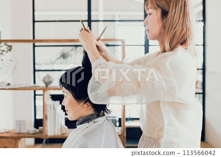 年輕女子在一家美容院切 113566042