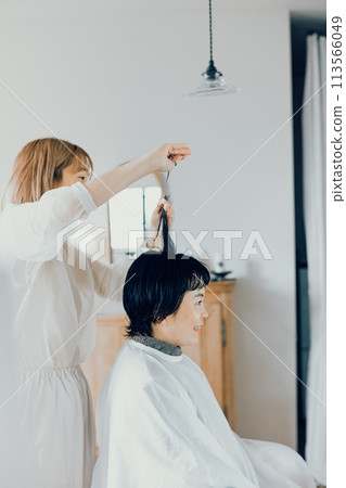 Young woman getting a cut at a beauty salon 113566049