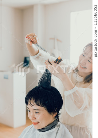 Young woman getting a cut at a beauty salon Young woman getting a cut at a beauty salon 113566052