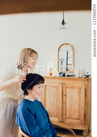 Young woman having her hair done at a beauty salon Young woman having her hair done at a beauty salon 113566059