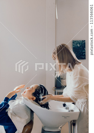 Young woman getting shampooed at a beauty salon 113566061