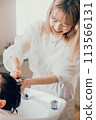 Young woman getting shampooed at a beauty salon 113566131