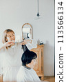 Young woman getting a cut at a beauty salon 113566134