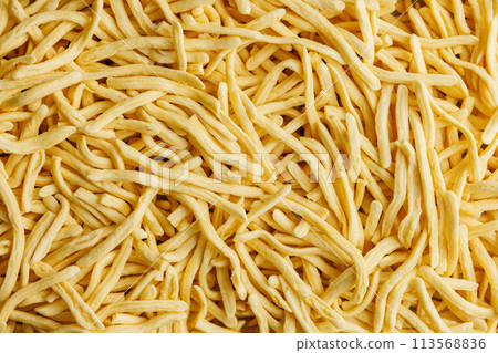 A lot of uncooked spaetzle pasta. Top view. A lot of uncooked spaetzle pasta. Top view. 113568836