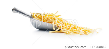 Uncooked spaetzle pasta in scoop isolated on white background. Uncooked spaetzle pasta in scoop isolated on white background. 113568862