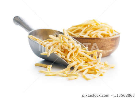 Uncooked spaetzle pasta in scoop isolated on white background. Uncooked spaetzle pasta in scoop isolated on white background. 113568863
