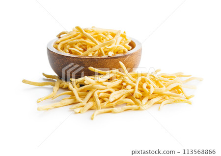 Uncooked spaetzle pasta in bowl isolated on white background. Uncooked spaetzle pasta in bowl isolated on white background. 113568866