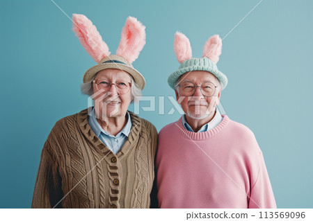 Happy old couple in bunny ears on blue background. Easter concept. space for text 113569096