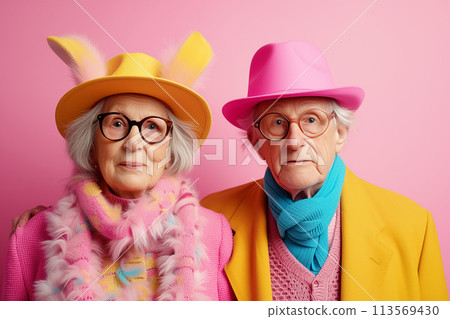 Happy old couple in bunny ears on pink background. Easter concept. space for text Happy old couple in bunny ears on pink background. Easter concept. space for text 113569430
