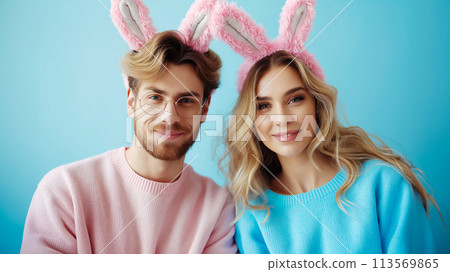 Happy couple in bunny ears on blue background. Easter concept Happy couple in bunny ears on blue background. Easter concept 113569865