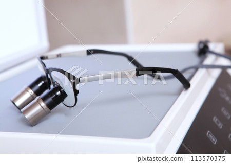 Dental binocular glasses. Dental magnifier. Dentistry and the concept of dental care. Modern dentistry. Dental binocular glasses. Dental magnifier. Dentistry and the concept of dental care. Modern dentistry. 113570375
