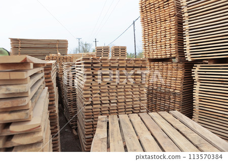 Wooden pallets for transportation of building materials. Wood harvesting workshop. The woodworking industry. 113570384