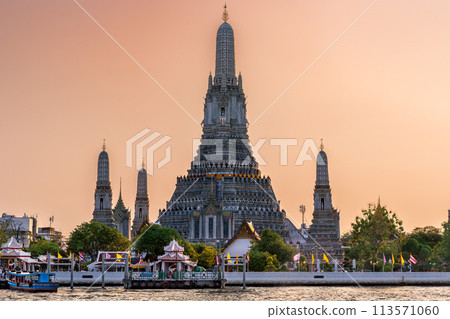 Wat Arun stupa, a significant landmark of Bangkok, Thailand, stands prominently along the Chao Phraya River, with a beautiful sunset sky. Wat Arun stupa, a significant landmark of Bangkok, Thailand, stands prominently along the Chao Phraya River, with a beautiful sunset sky. 113571060