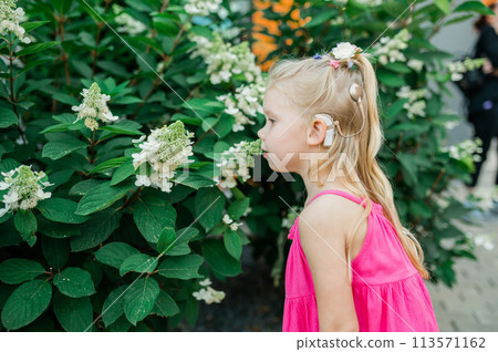 Child head with cochlear implant hearing aid. Hearing aid and medicine innovating technology and diversity inclusion concept. Copy space 113571162