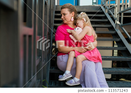 Child girl with cochlear implant with her mother spend time outdoor. Hear impairment and deaf community concept. Deaf and health concept. Diversity and inclusion. 113571243