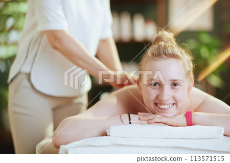 female therapist in massage cabinet making massage 113571515