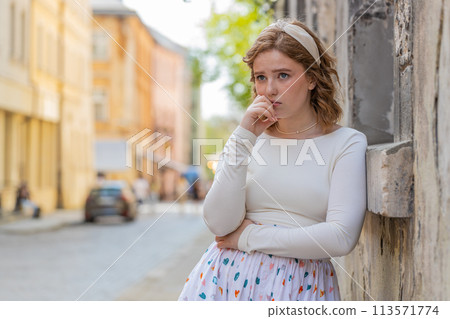 Sad unhappy frustrated young woman walking alone in city street feeling bad annoyed grief problem 113571774