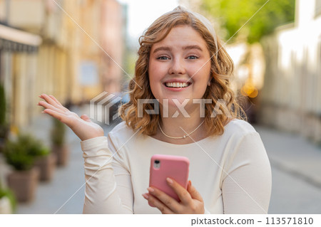 Happy redhead girl use smartphone celebrating win good message news lottery jackpot victory outdoors Happy redhead girl use smartphone celebrating win good message news lottery jackpot victory outdoors 113571810