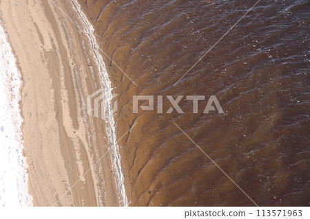 nature in winter on the banks of the Volga, ice with sand and snow, river sandy background. 113571963