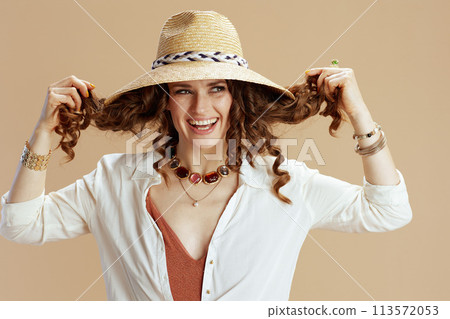 smiling elegant woman in blouse and shorts on beige 113572053