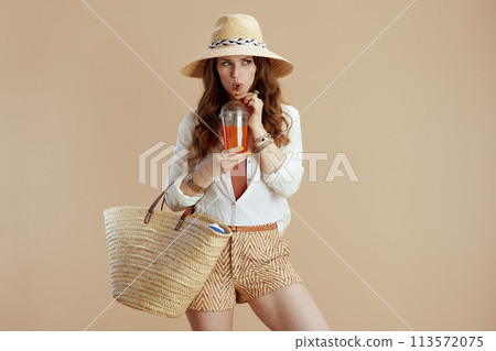 stylish housewife in blouse and shorts against beige 113572075