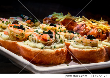 Tapas and pinchos at a food market in Spain. Traditional Spanish gastronomy 113572175