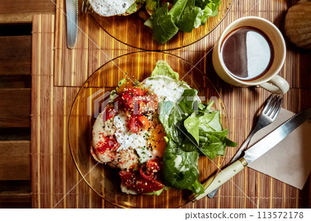 Breakfast at a cafe. Toast with egg, tomato, and spinach, overhead flat lay shot 113572178