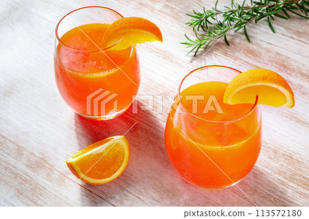 Orange drinks with rosemary on a wooden background, fresh pressed juice Orange drinks with rosemary on a wooden background, fresh pressed juice 113572180