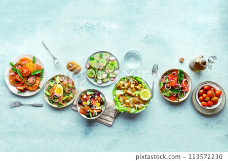Fresh salads, overhead flat lay shot of an assortment. Variety of plates 113572230