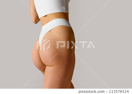 Close up photo of female body, buttocks against white studio background. female model posing in lingerie. Close up photo of female body, buttocks against white studio background. female model posing in lingerie. 113576524