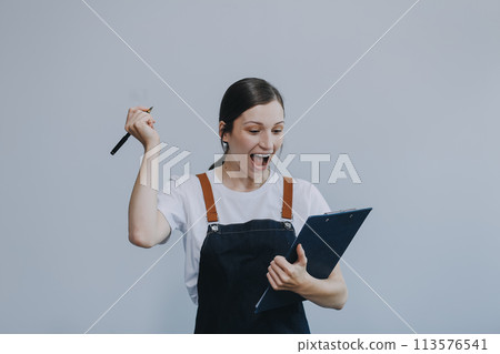 .Cheerful beautiful Asian woman wearing jeans overalls with excited doing winner gesture with arms raised isolated on white background. .Cheerful beautiful Asian woman wearing jeans overalls with excited doing winner gesture with arms raised isolated on white background. 113576541