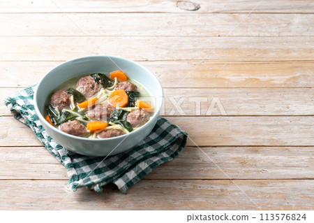 Italian Wedding Soup with meatballs and spinach on wooden table Italian Wedding Soup with meatballs and spinach on wooden table 113576824