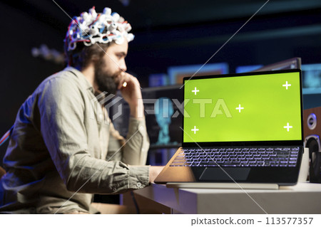 Man with EEG headset on writing code to transfer mind into virtual world, isolated screen laptop on desk Transhumanist using neuroscientific tech and chroma key notebook to gain superintelligence Man with EEG headset on writing code to transfer mind into virtual world, isolated screen laptop on desk Transhumanist using neuroscientific tech and chroma key notebook to gain superintelligence 113577357