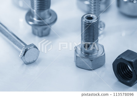 Close up scene the set of nut and bolts in the light blue scene. Close up scene the set of nut and bolts in the light blue scene. 113578096