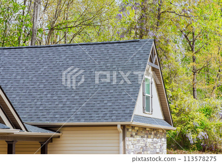 On newly constructed home, overlapping asphalt shingles are seen on roof On newly constructed home, overlapping asphalt shingles are seen on roof 113578275