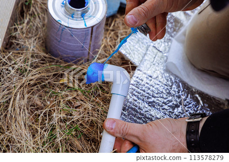 Before gluing pvc plastic pipe, plumber seals it with glue 113578279