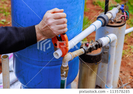 During repair work technician plumber uses special scissors to cut plastic PVC pipe During repair work technician plumber uses special scissors to cut plastic PVC pipe 113578285