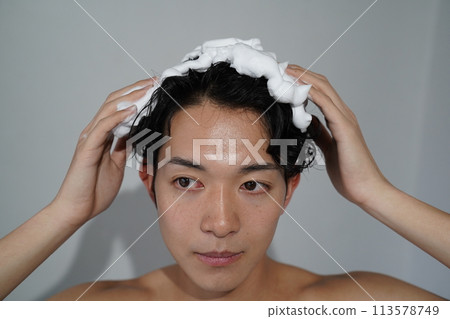Young man shampooing Young man shampooing 113578749