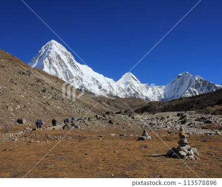 Trekking trail leading towards the Everest Base Camp and snow covered Mount Pumori, Nepal. 113578896
